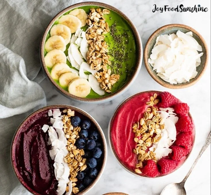 Colorful smoothie bowl topped with fresh fruits, nuts, and seeds