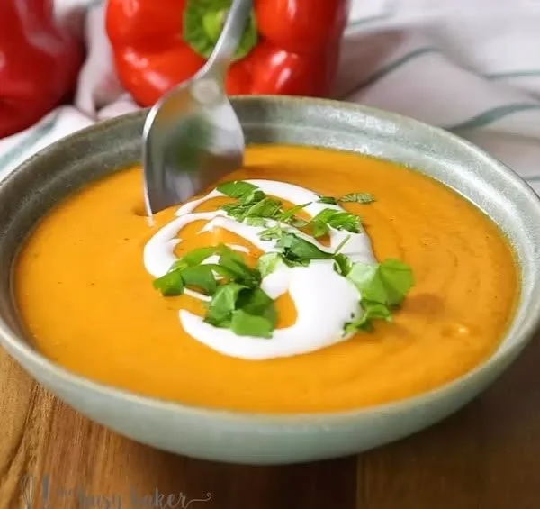 Creamy cauliflower soup topped with roasted red peppers in a bowl