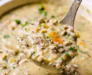 Bowl of creamy chicken wild rice soup garnished with fresh herbs
