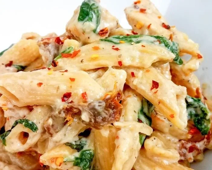 Creamy Tuscan chicken pasta with fresh herbs and sun-dried tomatoes
