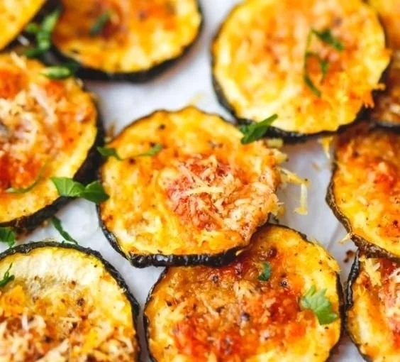 Crispy baked zucchini chips served in a bowl, a healthy snack option.