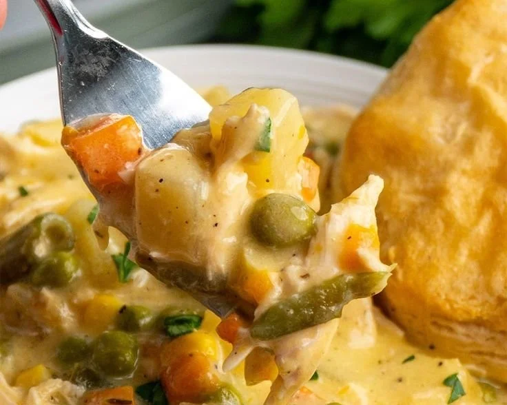 Delicious Crock Pot Chicken Pot Pie served in a bowl with vegetables and herbs.