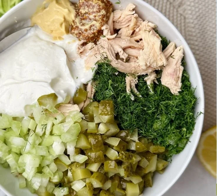 Bowl of Dill Pickle Chicken Salad with fresh ingredients and pickles