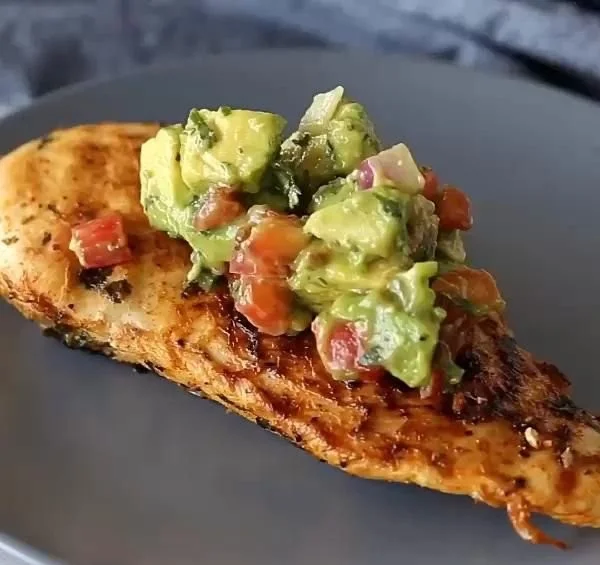 Healthy cilantro-lime grilled chicken topped with avocado salsa on a plate