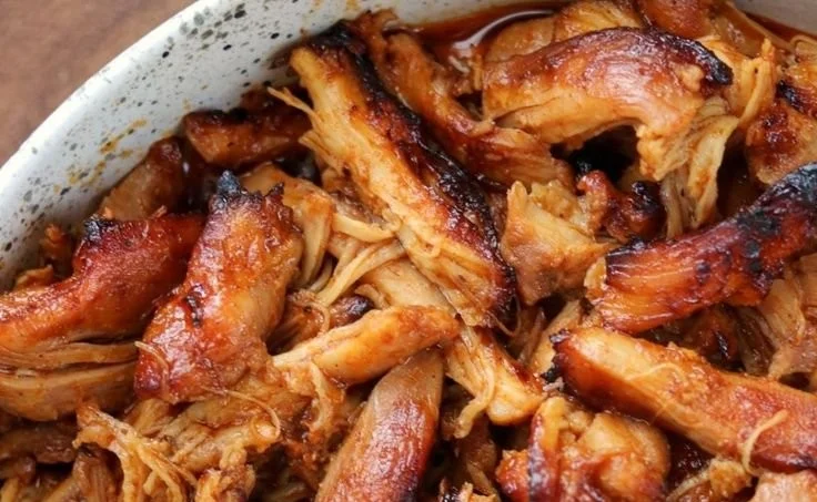 Instant Pot BBQ pulled chicken served on a bun with barbecue sauce