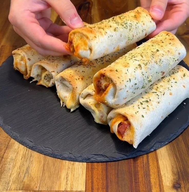 Low-calorie high-protein pepperoni pizza rolls freshly baked and served on a plate.