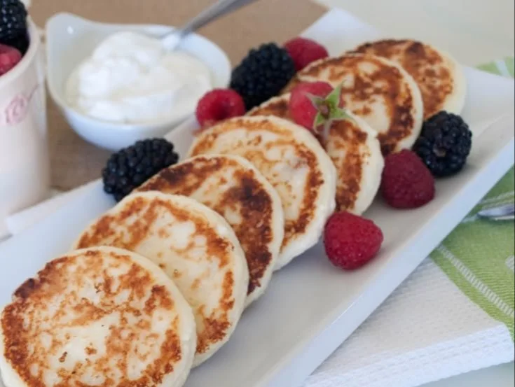 Plate of low carb cottage cheese pancakes topped with fresh fruits