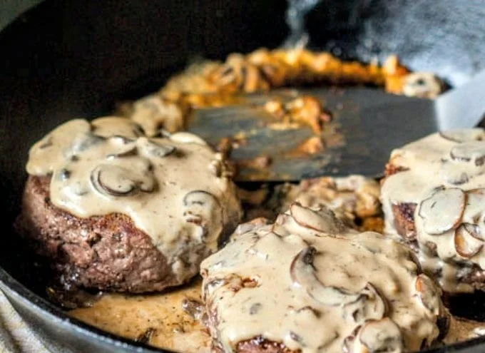 Low carb keto burger topped with creamy mushroom sauce on a plate