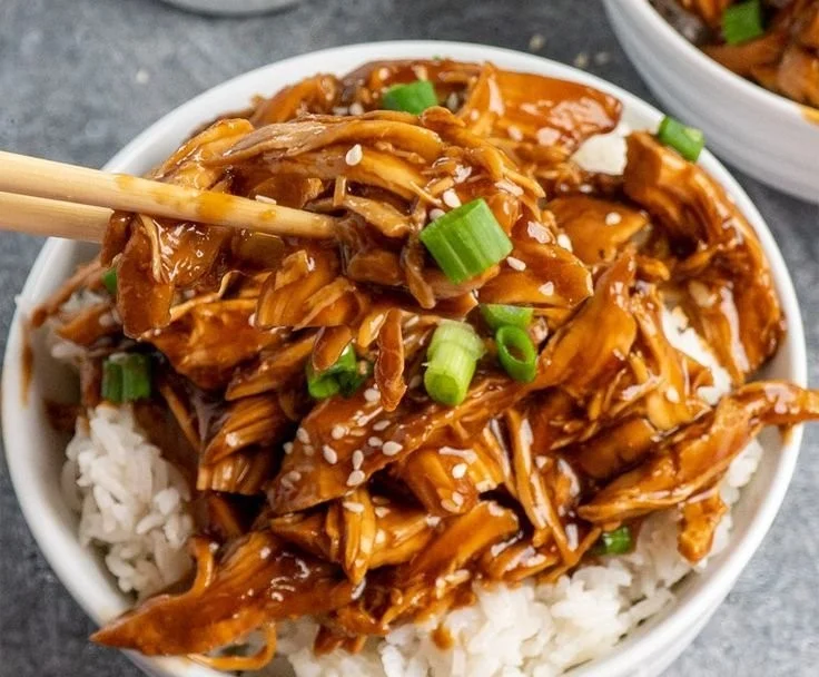 Plate of slow cooker shredded honey teriyaki chicken with rice and vegetables.
